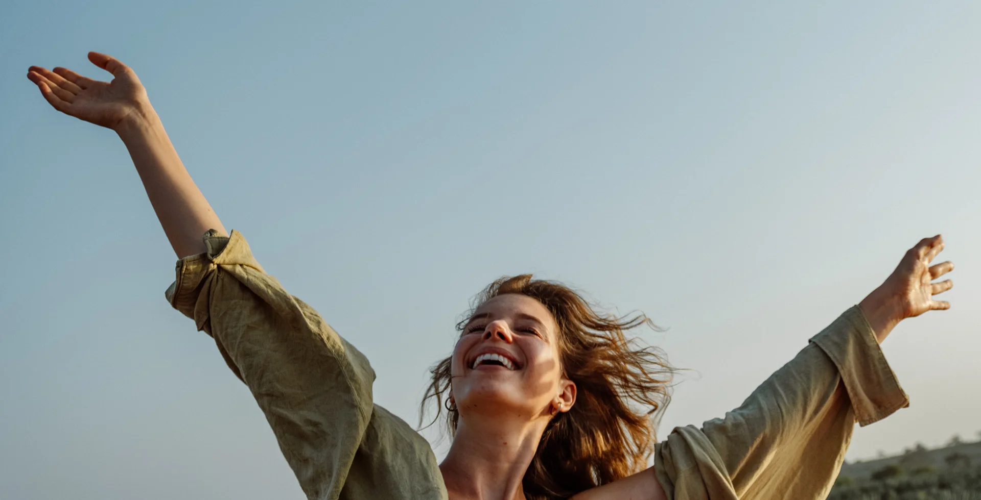 Woman smiling and raising hands to the sky
